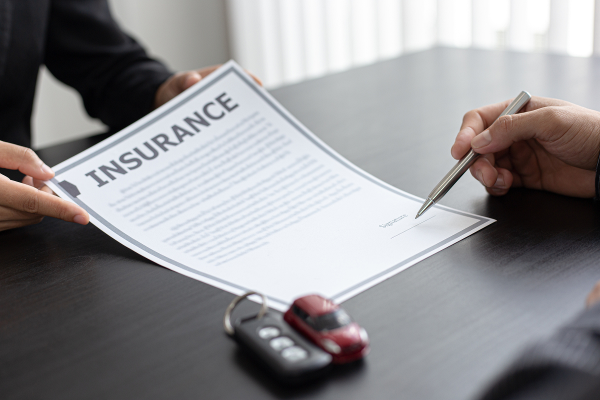 Image showing a piece of paper titled "insurance" on a dark table